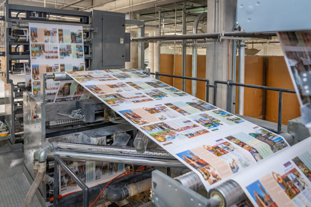 Printed signatures running through a Komori web offset press at Solo Printing