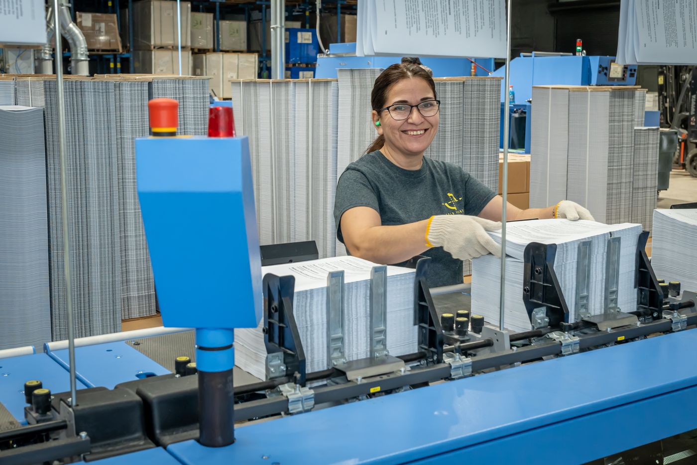 Solo Printing operator with finished magazines on the bindery line in Miami
