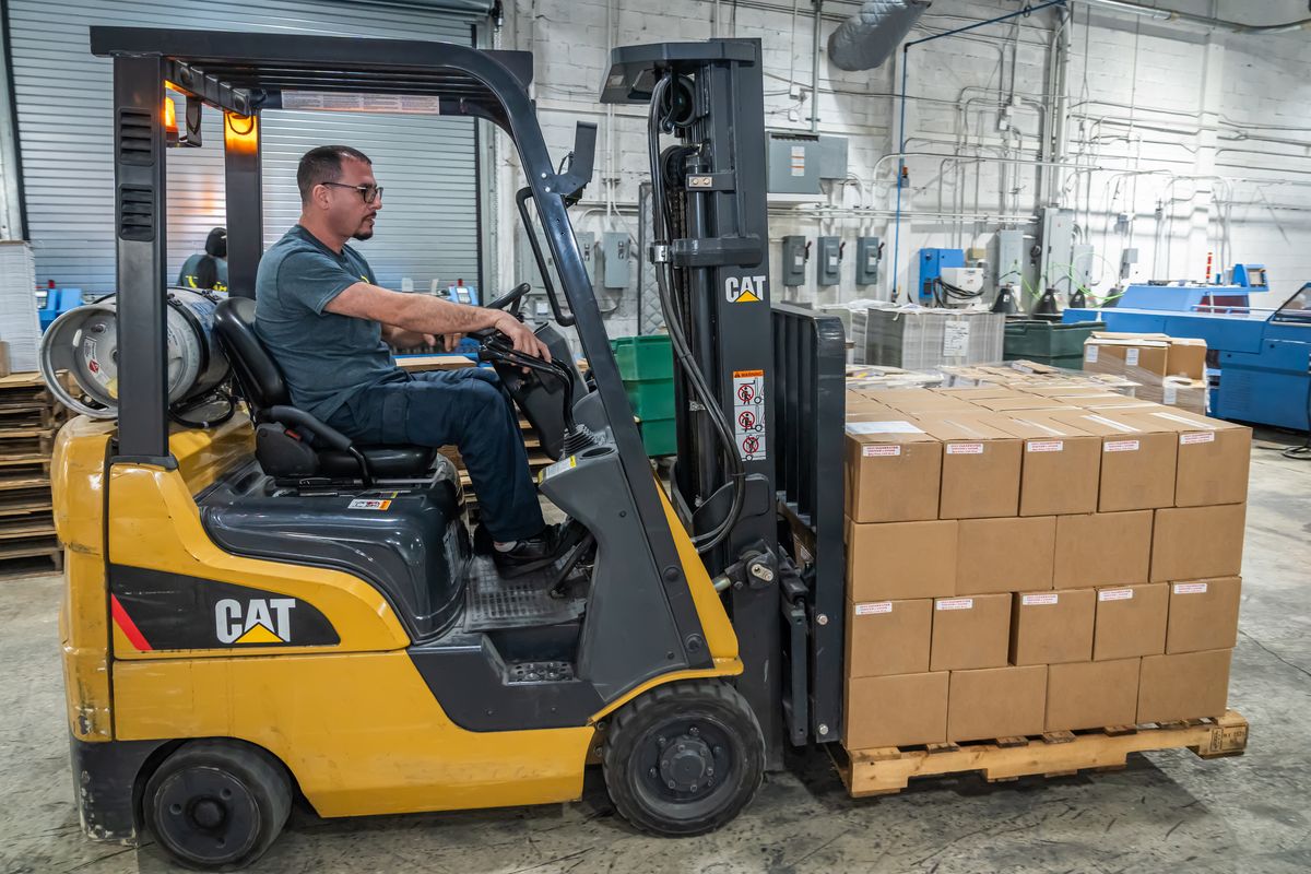 Forklift moving finished cartons at the Solo Printing plant in Miami