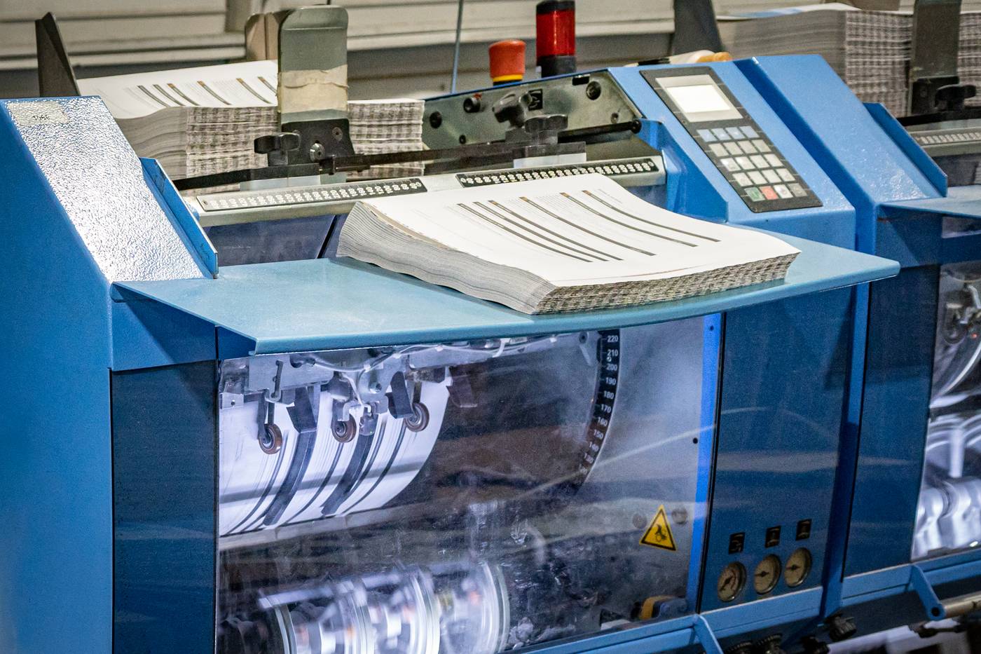 Booklets running through the saddle-stitch bindery line at Solo Printing in Miami